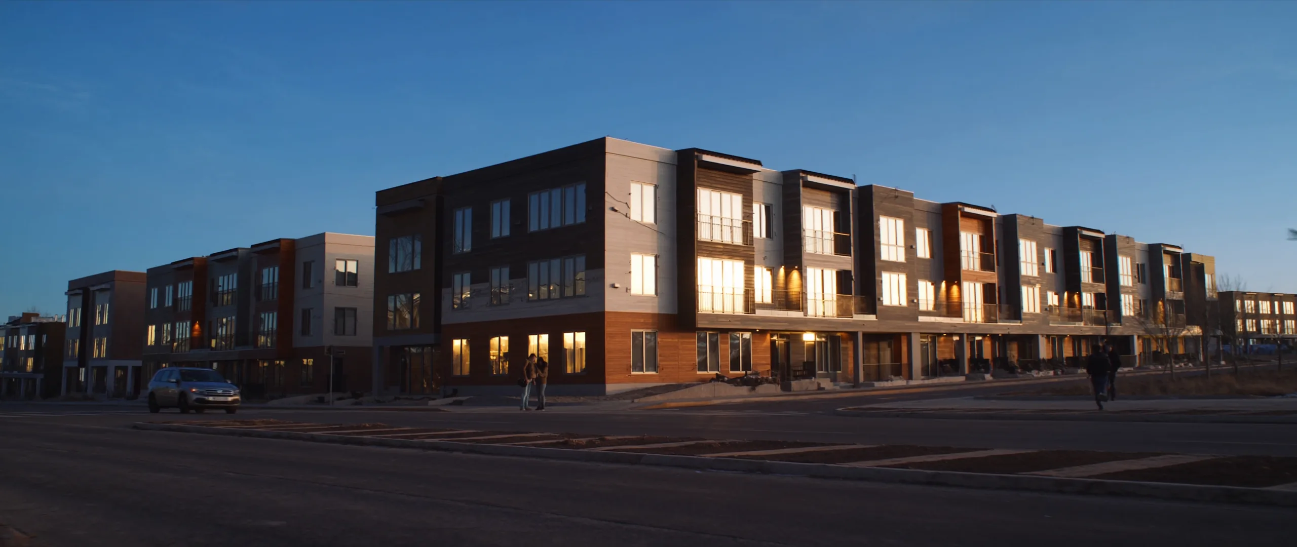 Street of newly built multi-unit rental buildings in Alberta at dusk